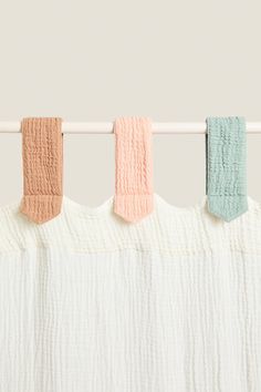 four pieces of cloth hanging on a clothes line with the colors of pastel blue, pink, and green