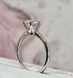 a close up of a diamond ring on top of a book