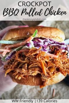 a hand holding a pulled pork sandwich with coleslaw