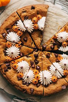 a chocolate chip cookie pie with white and orange flowers on top, cut into slices