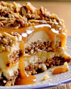 a piece of cheesecake covered in nuts and caramel sauce