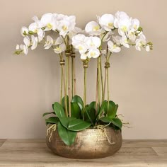 some white flowers are in a gold vase