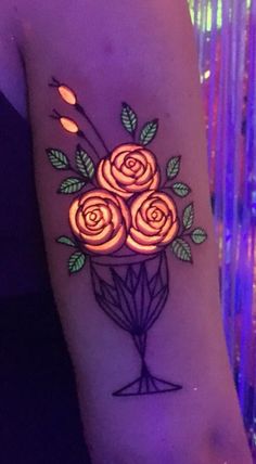 a woman's arm with flowers and leaves painted on the back of her arm