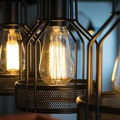 three light bulbs are hanging from the ceiling in an industrial style caged lamp fixture