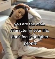 a woman sitting on the floor with her head in her hair and text that reads, you are the main character in your life don't focus on other people