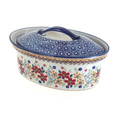 a blue and white casserole dish with flowers on it's rim,