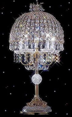 a crystal table lamp on top of a black surface with stars in the background,