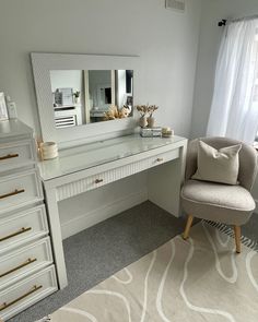 a white desk with a chair, mirror and dresser in a room that is well decorated