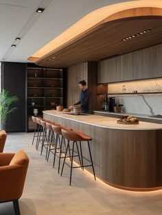 a man standing in front of a kitchen counter with lots of stools around it