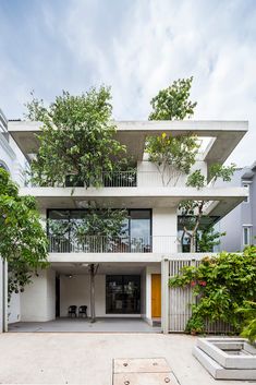 an apartment building with several balconies and trees on the balcony area, surrounded by concrete planters