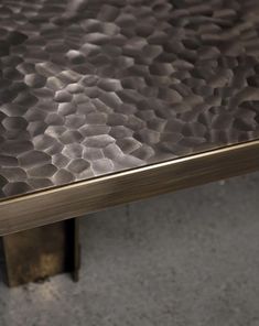 a close up view of a metal table with wavy designs on the top and bottom