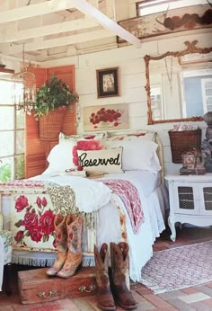 a room with a bed, rugs and boots on the floor in front of it