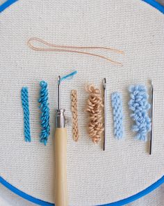 there are four knitting needles and five crochet hooks on the embroidery board with yarn