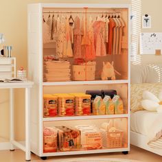 an organized closet in a bedroom with clothes and other items on the shelves next to a bed