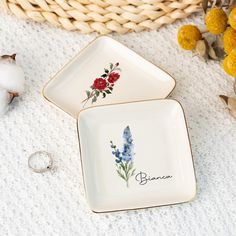 two plates with flowers painted on them next to cotton