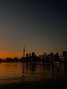 the sun is setting over a city skyline as it reflects in the water on a clear day