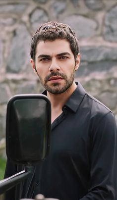 a man standing in front of a mirror with his hand on the handlebars