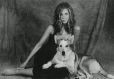 a woman is sitting on the floor with her dog and posing for a photo together