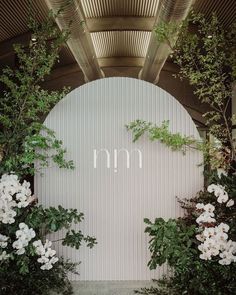 the entrance to an outdoor wedding venue with white flowers and greenery