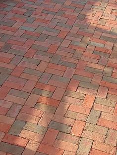 a fire hydrant sitting on the side of a brick road next to a tree