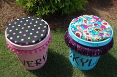 two colorful trash cans sitting in the grass