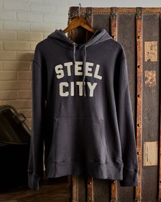 Our Vintage Stitched Logo Pullover is crafted with luxurious comfort in mind. Made from a mid-weight 400 gram 100% cotton that's pre-shrunk for the perfect fit. Garment dyed and washed for a soft finish, featuring our embroidered Steel City Logo. Model is 6’3” and 195 lbs, wearing a size large. 10 Logo, City Logo, Logo Mugs, Steel City, Strapback Hats, For Sale Sign, Shirt Shop, Pullover Hoodie, Trucker Hat