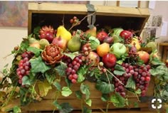 a wooden box filled with lots of different types of fruit on top of a table