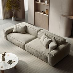 a living room filled with furniture and a white table in front of a large window