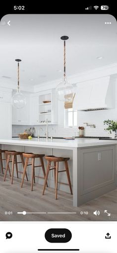 an image of a kitchen with white cabinets and wooden stools on the counter top