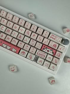 a keyboard with hello kitty stickers on the keys and some dices around it