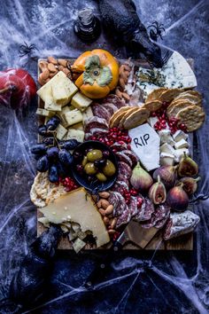 an assortment of cheeses and meats on a cutting board