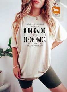 a woman wearing a shirt that says, there is a fine line numerator and denomimator