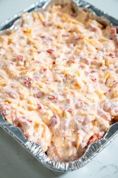 an uncooked casserole dish with cheese and meat