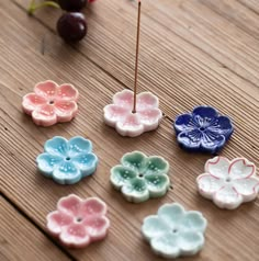 several small flower shaped buttons sitting on top of a wooden table