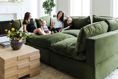 three women and two children sitting on a green couch