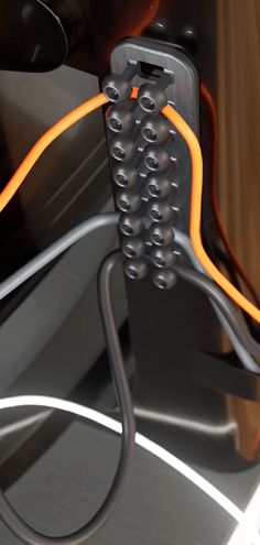 an orange and black cable is connected to the side of a car