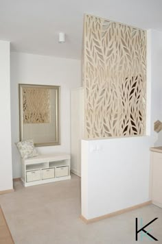 a living room with white furniture and a decorative screen on the wall above it's fireplace