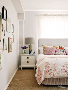 a bedroom with white walls and pictures on the wall