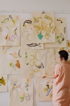 a woman is looking at paintings on the wall