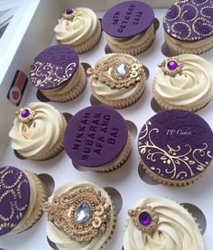 there are many cupcakes with purple frosting on the top and gold decorations