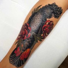 a black bird with red flowers on it's arm