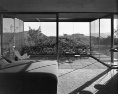 a living room with large glass walls and floor to ceiling windows