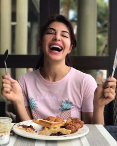 a woman sitting at a table with food and utensils in front of her