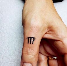 a woman's hand with a small pi symbol tattoo on it