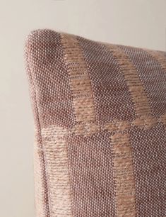 an upholstered cushion with brown and white checkered fabric on the back side