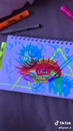 a hand holding a neon green pen in front of a spiral notebook