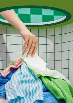 a woman's hand reaching for a rag on top of a pile of clothes