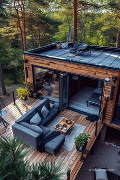 an aerial view of a house in the woods with couches, tables and chairs