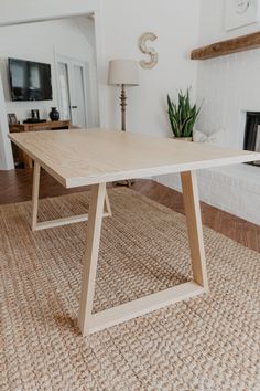 a wooden table sitting on top of a rug in front of a fire place and fireplace