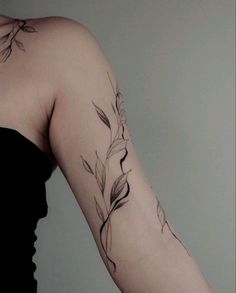 a woman's arm with flowers and leaves tattooed on the back of her shoulder